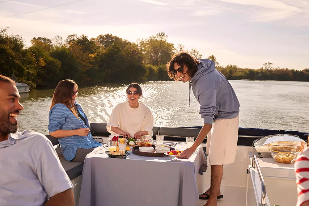 Vier Freunde machen ein BBQ auf einem Le Boat Hausboot